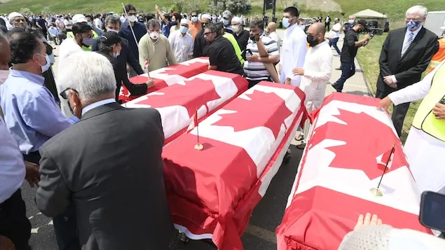 Caskets draped in Canadian flags arrive at a funeral for the four Muslim family members killed in a deadly vehicle attack, at the Islamic Centre of Southwest Ontario in London, Ont., on Saturday, June 12, 2021. Talat Afzaal, 74, her son Salman Afzaal, 46, his wife Madiha Salman, 44, and their 15-year-old daughter Yumna Salman all died last Sunday night while out for a walk after a man in a truck drove them down in what police have called a premeditated attack because they were Muslim. THE CANAD