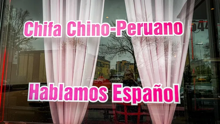一家餐厅的橱窗上写着 “我们说西班牙语”。